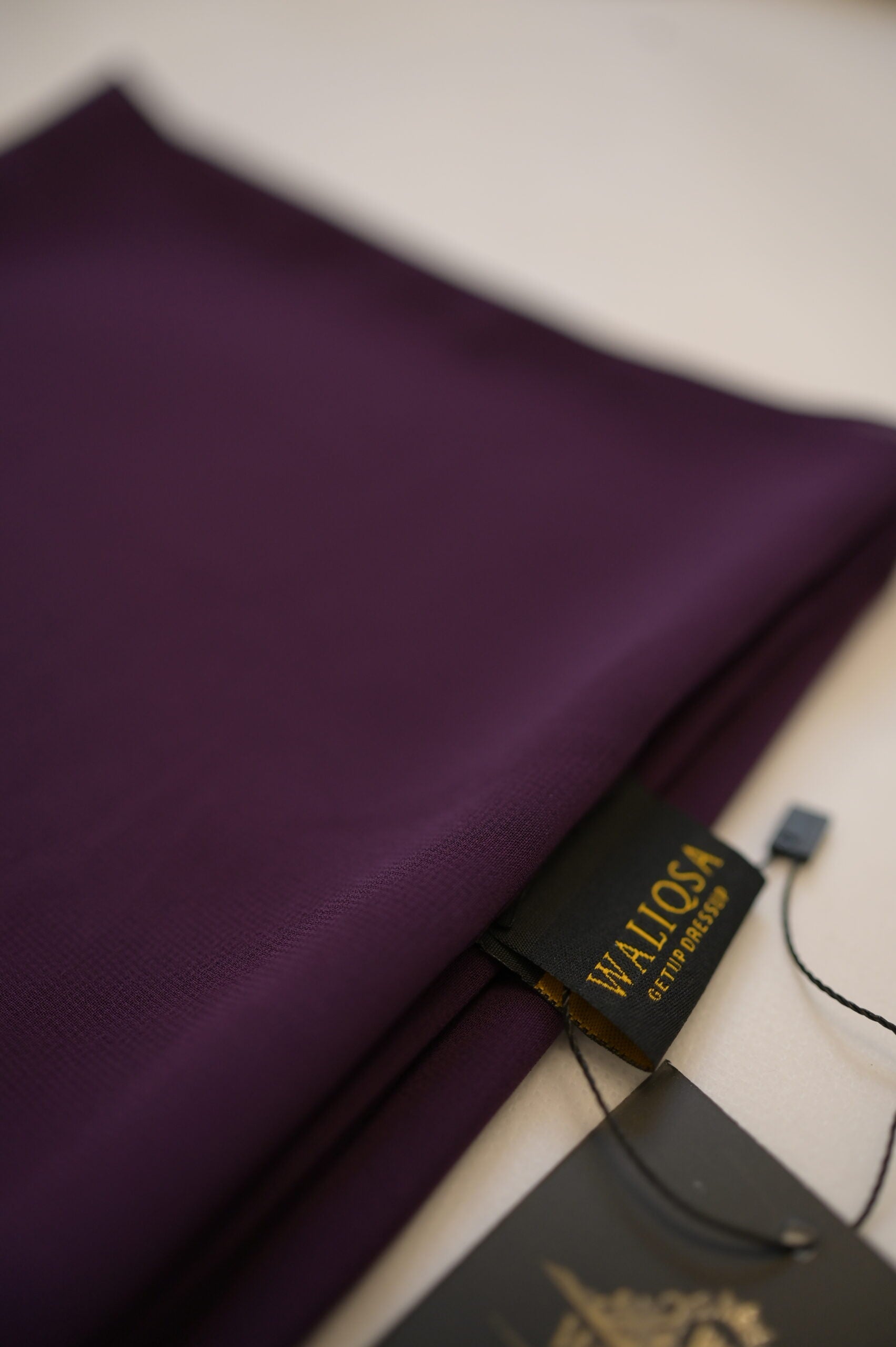 Eggplant purple chiffon hijab neatly folded, showcasing airy lightweight texture.