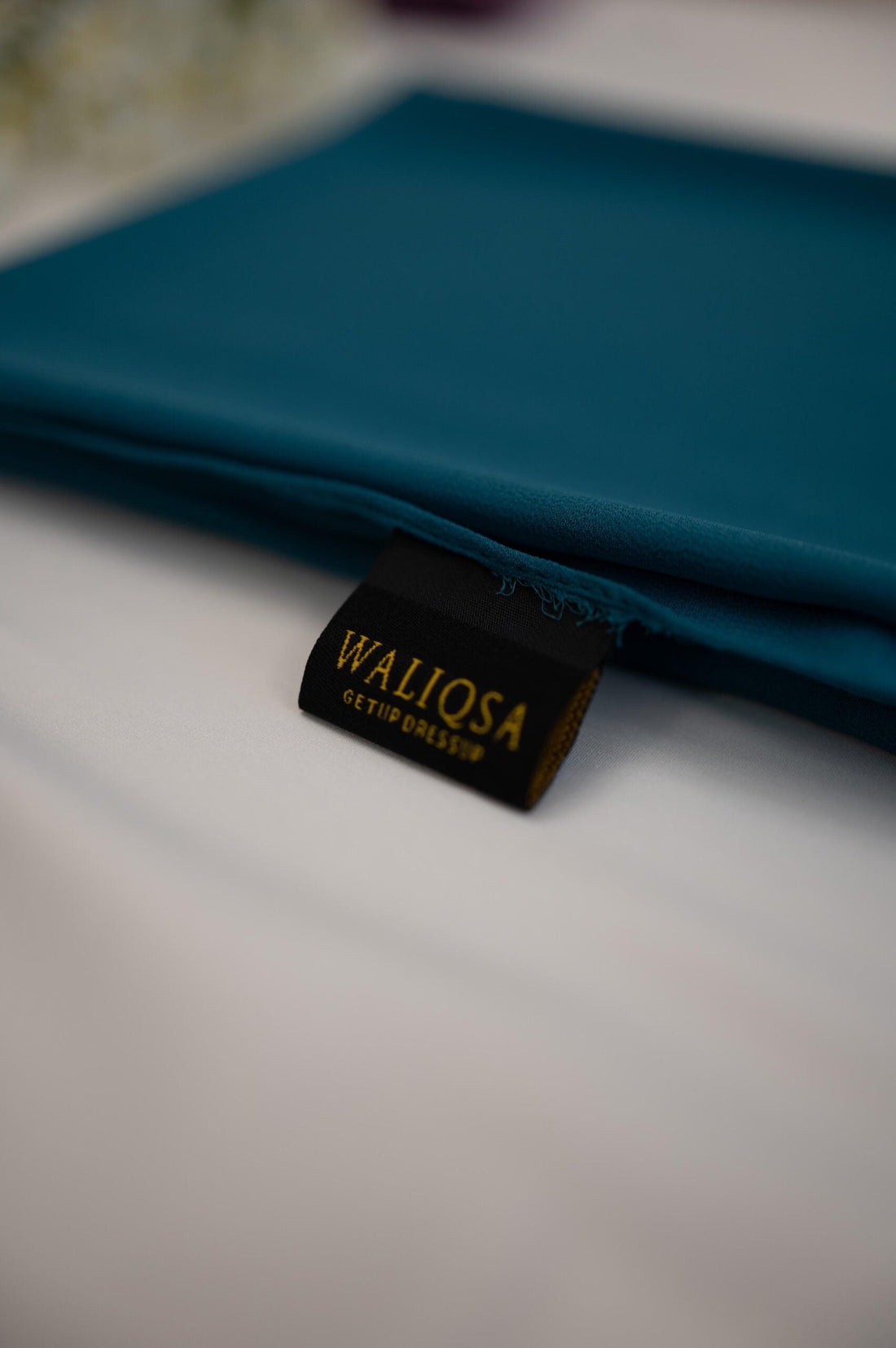 Zinc-colored chiffon hijab folded neatly, showcasing smooth and lightweight fabric.

