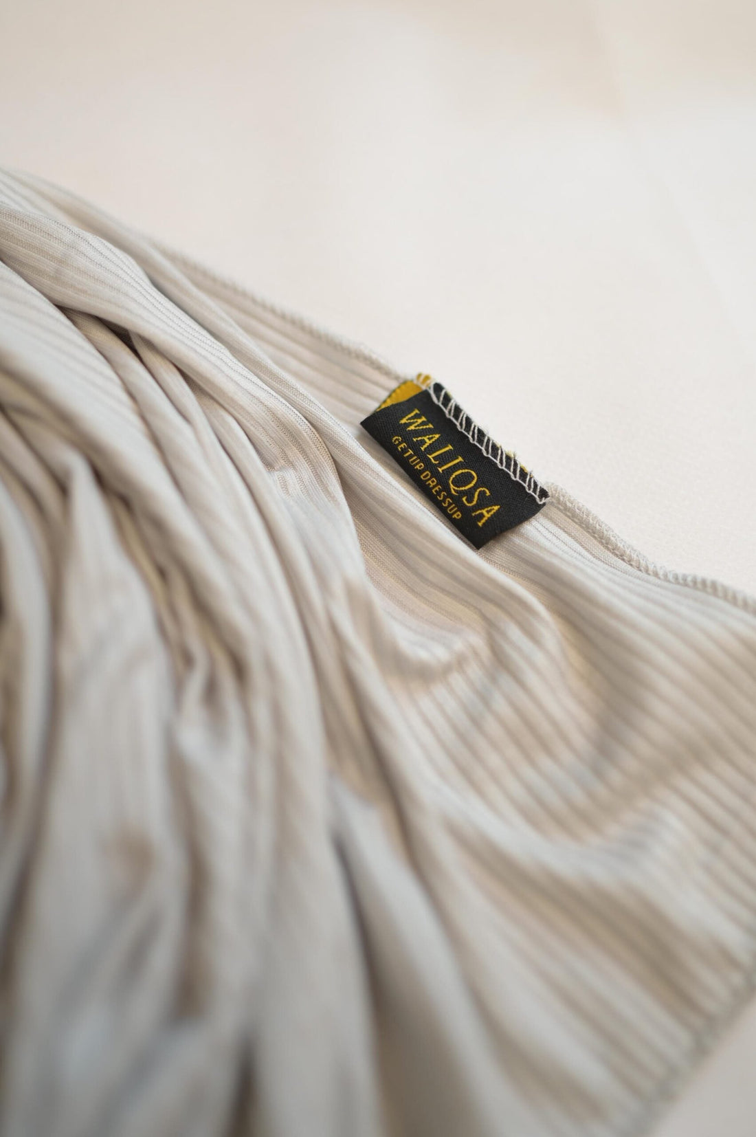 Folded silver rock jersey hijab placed on clean background, showing soft texture.

